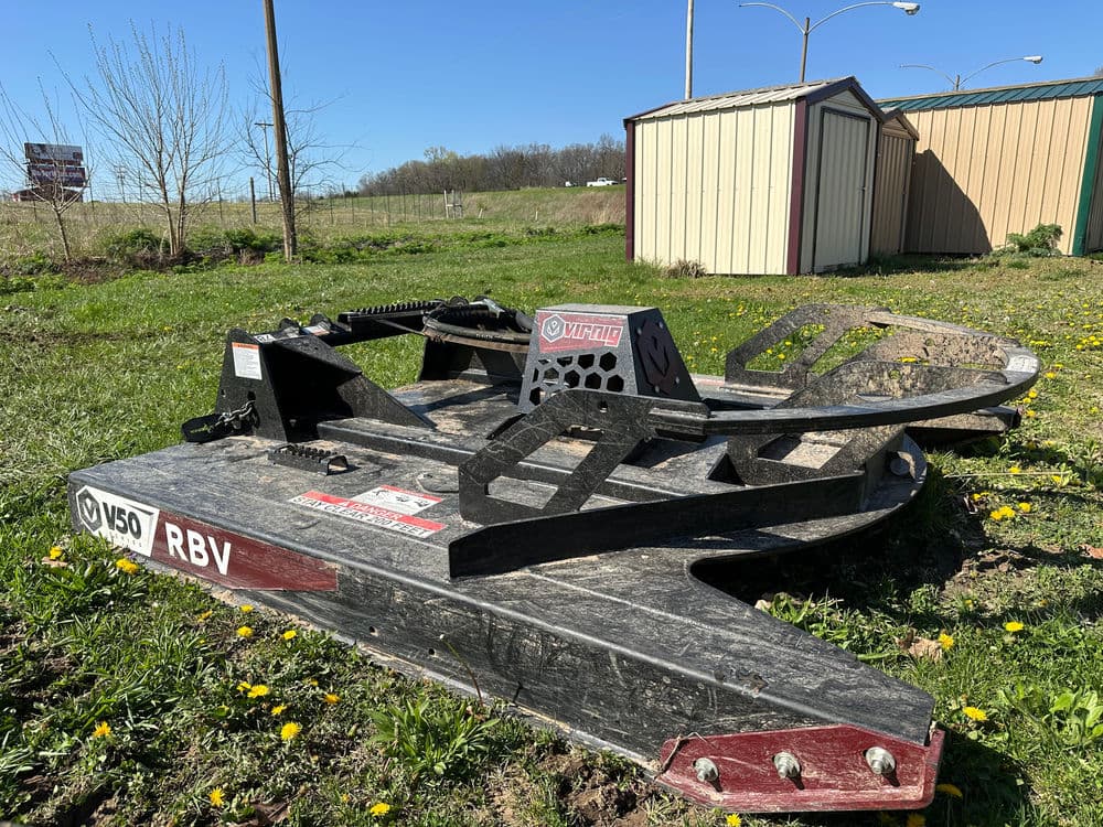 V50 RBV land clearing equipment on grass with storage sheds in background.